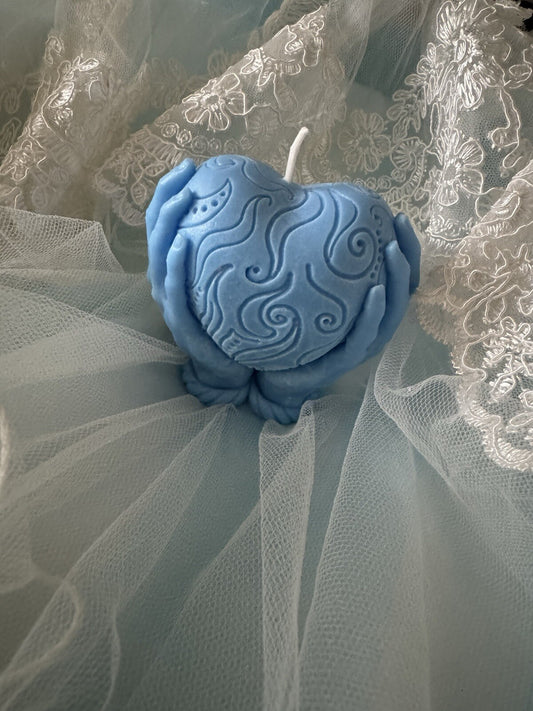 Scented vanilla candle blue heart holding